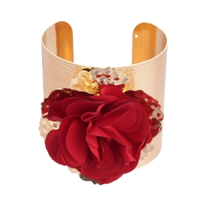 Golden cuff bracelet with a large red fabric rose and textured metallic finish