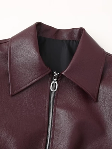 Detail of deep red PU leather jacket collar with silver zipper and black lining texture