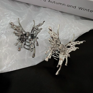 Detail of silver liquid metal butterfly hair claws with metallic finish and y2k punk design