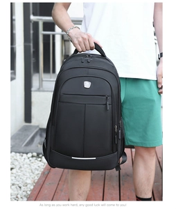 Detail shot of a black business laptop backpack with top handle held by a male model outdoors