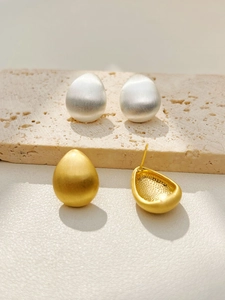 Detailed view of matte brushed water drop earrings in silver and gold metal finishes