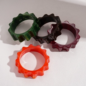 Exaggerated geometric wavy acrylic resin flower bangles in dark green and amber tones