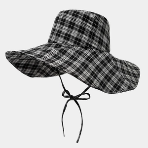 Detail of wide brim sun hat with black and white plaid pattern and adjustable chin strap