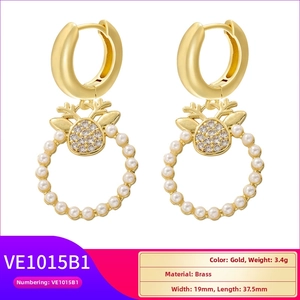 Detail view of gold brass reindeer earrings with sparkling zircons and faux pearls