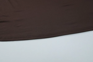 Detailed close-up of dark brown knit dress featuring high-quality double-needle stitching