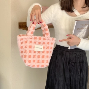 Detailed close-up of pink checkered plush tote bag with lamb wool texture and minimalist label