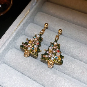 Detail view of Christmas tree earrings with green enamel, colorful gems, and pearls