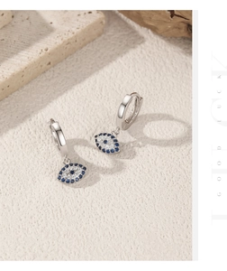 Close-up of S925 silver evil eye stud earrings with blue gems and white zircons