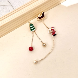 Détail de boucles d'oreilles de Noël asymétriques avec charms Père Noël