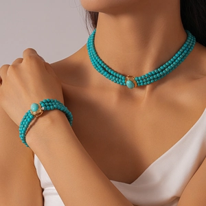 Detail of bohemian three-layer beaded necklace and bracelet with green stone oval pendant