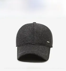 Detail view of dark grey wool baseball cap with refined texture and metal logo