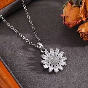 Gros plan d'un collier pendentif tournesol en argent avec zircon dans un écrin à bijoux