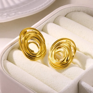 Detailed macro shot of gold flower petal earrings in a cream velvet jewelry box
