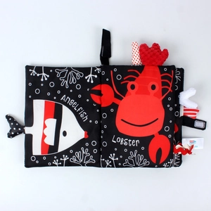 Detail of high-contrast baby soft book featuring angelfish and lobster with sensory tags
