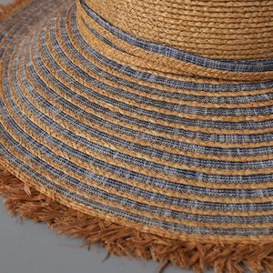 Macro detail of natural straw and blue denim patchwork weave with frayed bohemian edges