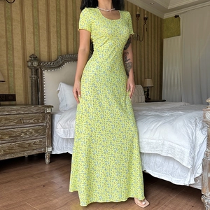 Nahaufnahme eines gelben Maxikleides mit Blumenmuster und schlanker Passform im Vintage-Stil