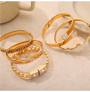 Detailed shot of gold bangles featuring colorful zircons and grooved metal textures
