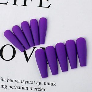 Macro detail of dark purple matte coffin press on nails displayed on stylish magazine
