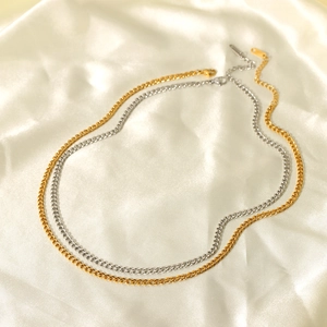 Minimalist Cuban link necklaces in gold and silver steel on elegant white satin background