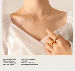 Close-up of heart pendant necklace and geometric ring in 18K gold plated titanium steel