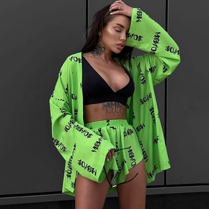 Detail of neon green lounge set with black graffiti print and kimono-style sleeves