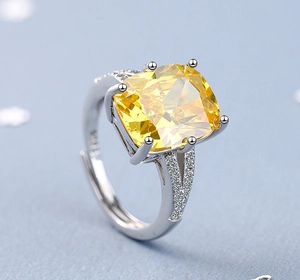 Macro detail of silver ring with cushion-cut yellow gemstone and small diamonds