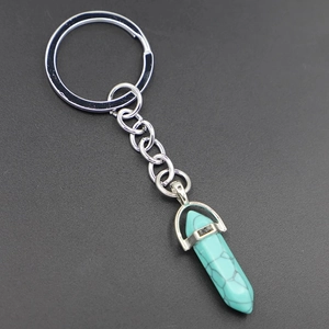 Detail shot of hexagonal turquoise stone keychain with silver metal ring and chain