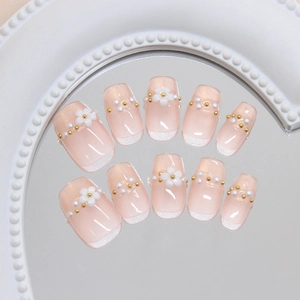 Handmade press-on nails with nude pink base, white French tips, pearl accents and floral detail