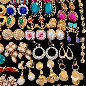 Collection de boucles d'oreilles vintage avec perles, émail et cristaux sur fond noir