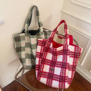 Detail of red and green plaid faux fur tote bags with soft fleece texture on a chair