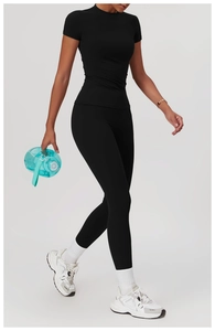 Dynamische Seitenansicht eines schwarzen Yoga-Sets mit Leggings und kurzärmeligem Oberteil