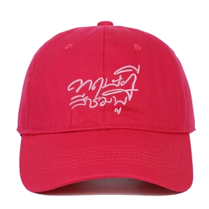 Detailed close-up of red cotton baseball cap featuring pink Thai script embroidery