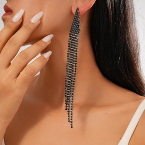 Detail view of long black rhinestone tassel earrings on a model for a chic look