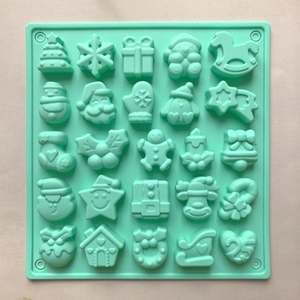 Detailed top view of mint green silicone mold with 25 diverse Christmas themed patterns