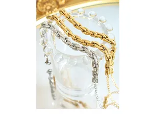Close-up of gold and silver chunky box chain bracelets with lobster clasp detail
