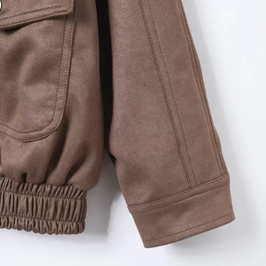 Detail of brown suede jacket showing stitching on cuffs and side pockets with soft texture