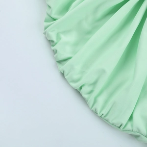 Détail d'une robe dos nu vert menthe montrant le tissu plissé et la maille douce