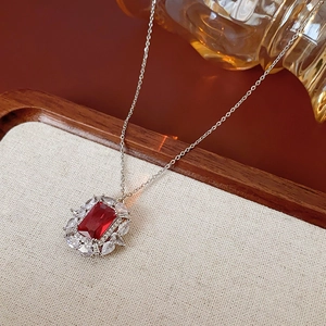 Détail du pendentif zircon rouge carré avec pierres blanches sur collier chaîne argentée