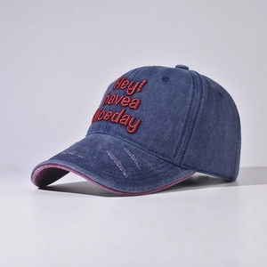 Detail der Stickerei auf einer Vintage-Baseballkappe mit Used-Look und violettem Futter