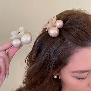 Elegant pearl flower hair clips in white and pink worn on wavy brown hair