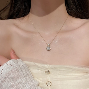 Close-up of a 14k gold plated necklace with a large round cubic zirconia floral pendant