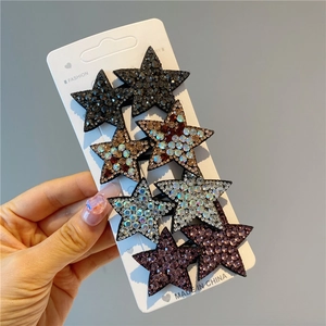 Close-up of star-shaped rhinestone hair clips set in black, silver and purple