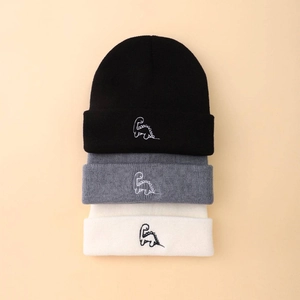 Detailed view of high-density knit beanies with embroidered dinosaur motifs in three colors