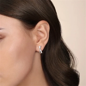Detailed view of silver hoop earrings featuring a layered crisscross design with zircon