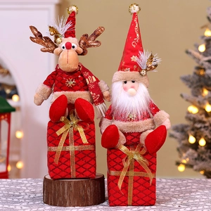 Close-up of Santa and reindeer figurines sitting on red sequined Christmas gift boxes