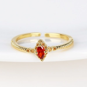 Detailed macro view of 18K gold plated twisted ring with red marquise zircon stone