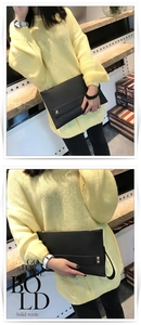 Detail van zwarte lederen envelop clutch met metalen noppen en een handige polsband