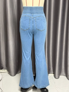 Détail de la taille haute élastique et des poches arrière de ce jean évasé bleu clair