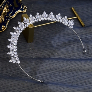 Detail of silver tiara headband with sparkling leaf-shaped cubic zirconia on blue fabric