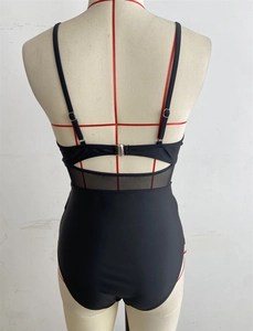 Detail of black one-piece swimsuit with mesh paneling and open back design